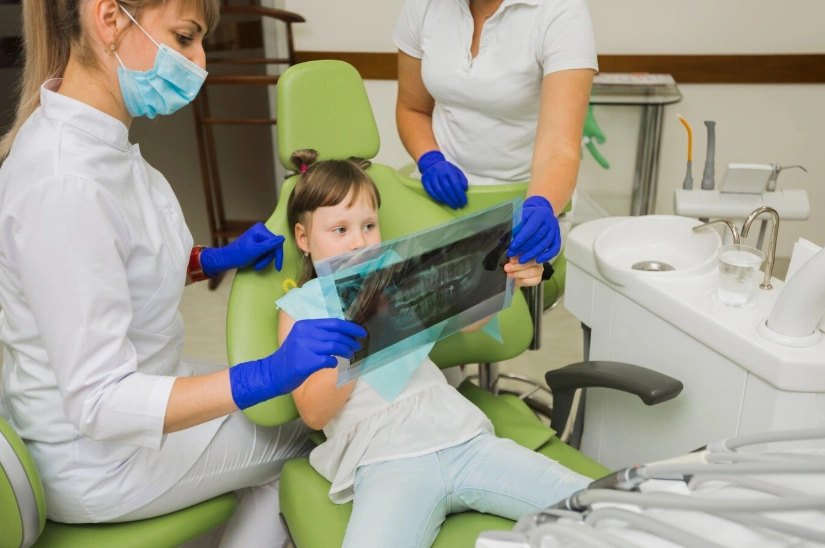 dentist and girl patient looking at radiography