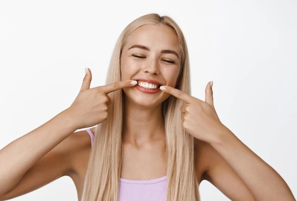 girl points fingers at her front teeth